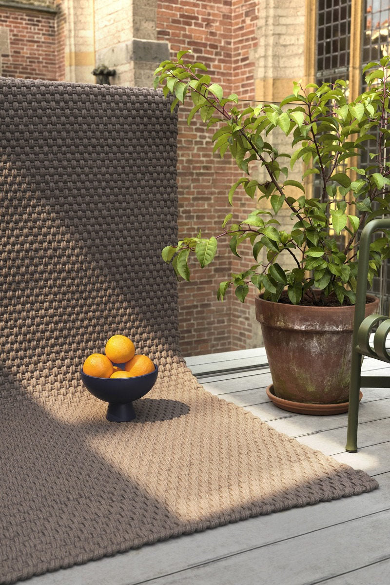 Brink & Campman Lace Grey Taupe rug placed on a patio with teak chairs and neutral cushions

