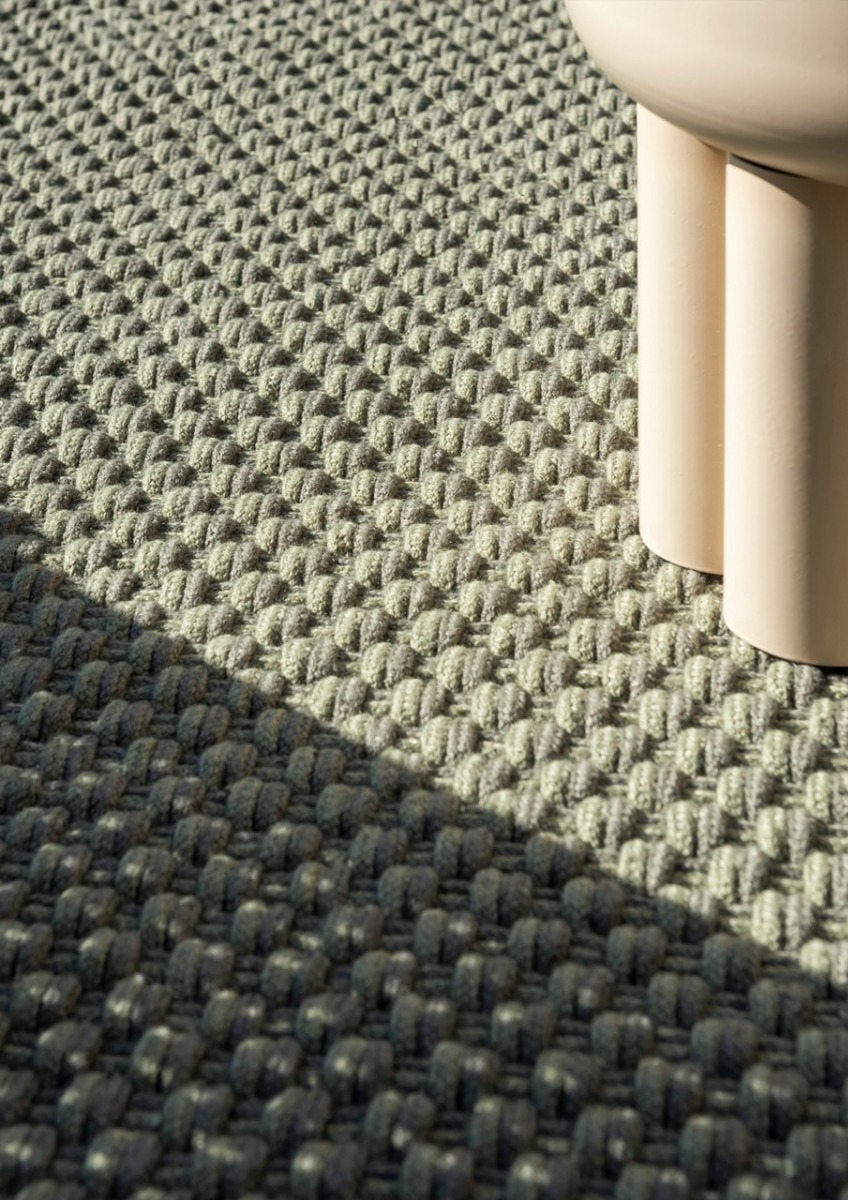 Close-up of handwoven recycled PET texture in thyme and pine green flatweave