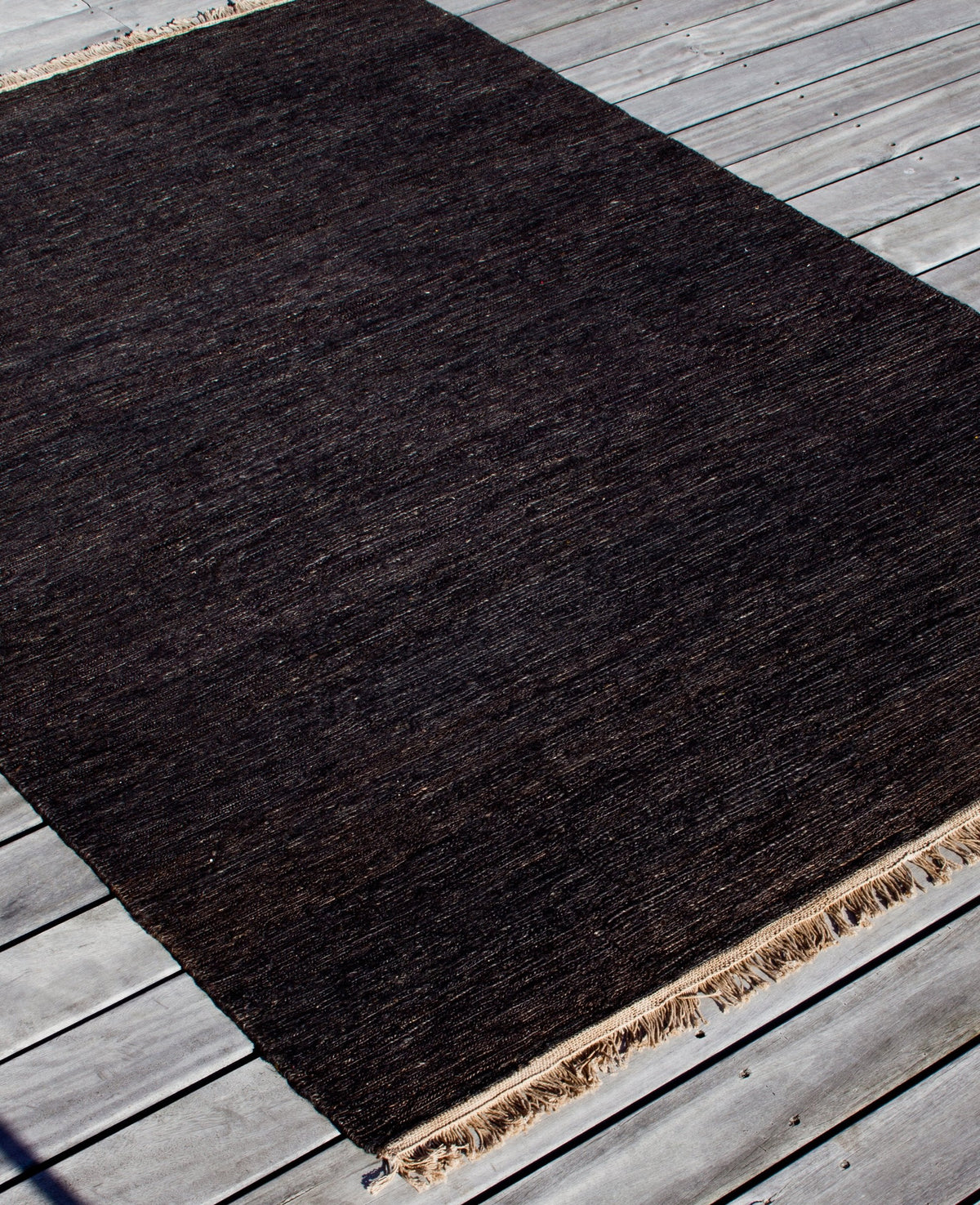 Massimo Sumace Black jute rug with fringes, perspective view